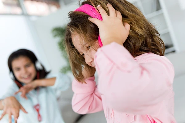Young girl wearing pink headphones to manage anxiety and sensory overload.
