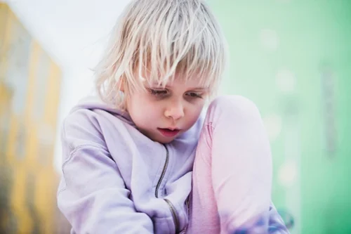 Young child looking down with an anxious expression, illustrating signs of anxiety in children.