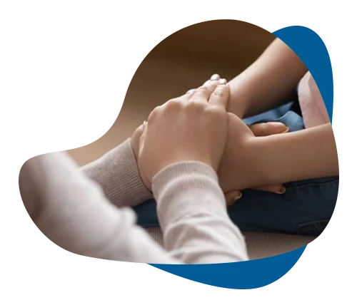 Therapist gently holding a child's hands during grief counselling in Richmond Hill.