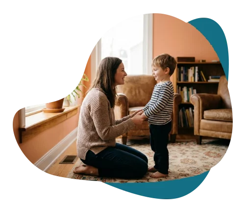 Mother kneeling at eye level and holding her young son’s hands, representing parent coaching in Richmond Hill.