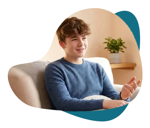 Teenage boy smiling and talking openly on a sofa during a teen counselling session at Alpha Child Therapy, Richmond Hill.